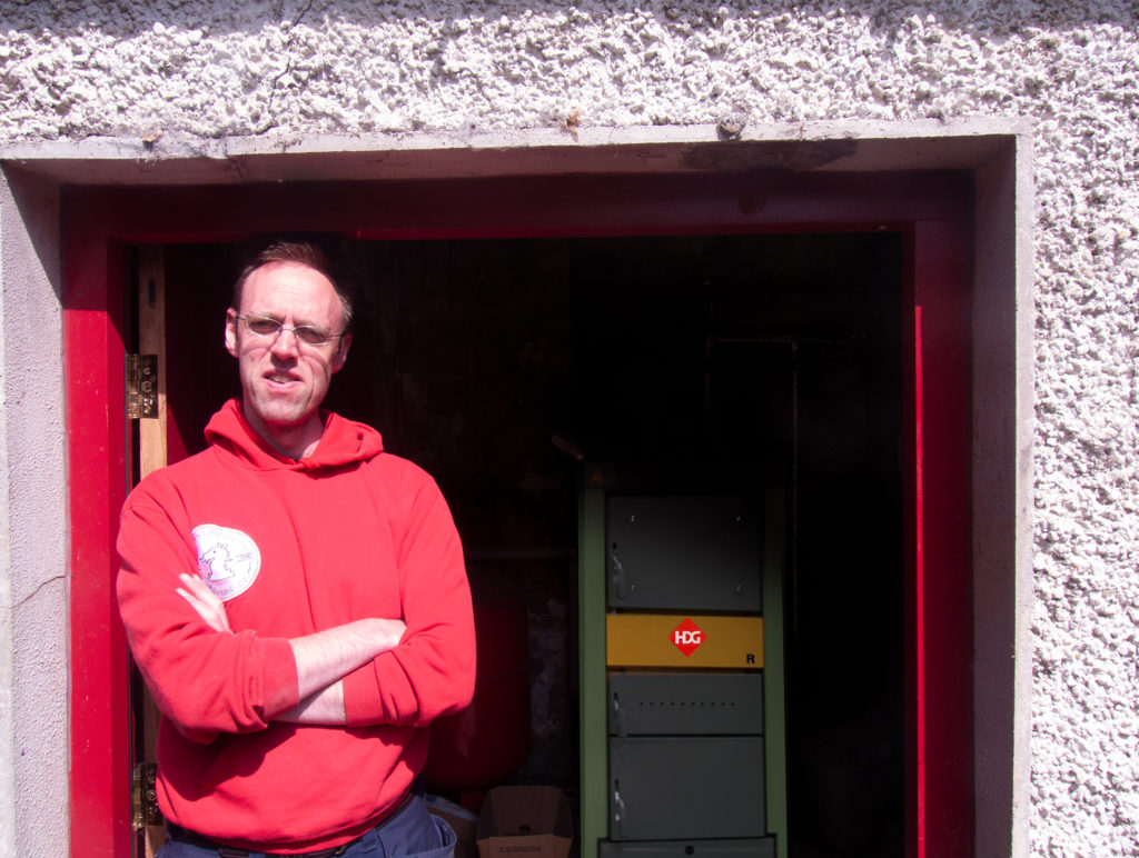 David Walsh-Kemmis stands by the door of the boiler shed at Ballykilcavan House that houses the HDG-R boiler and the 2000L accumulator tank.